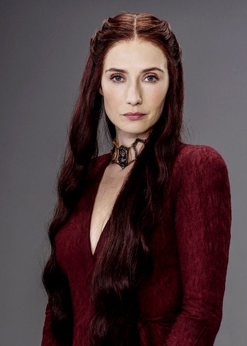 Melisandre Game of Thrones Halloween costume full look — deep crimson floor-length gown, long red wavy wig, gold ruby choker necklace, and red low heel boots