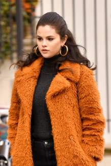 Selena Gomez as Mabel Mora in Only Murders in the Building, showing the character's signature warm yellow and orange color palette with red headphones