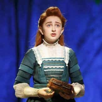 Winnie Foster Tuck Everlasting Musical cosplay reference showing the full character look, period lace blouse, flared midi skirt, long orange wig with purple headband, black tights, and brown lace-up boots