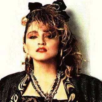 Madonna 80s Wild Child cosplay styling reference — black tutu, leopard bolero, cross jewelry, teased blonde wig with black bow