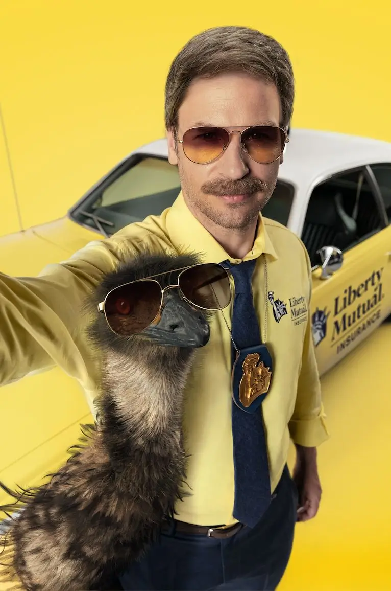 Limu Emu and Doug from Liberty Mutual taking a selfie together, Doug in his yellow shirt and aviator sunglasses, Limu Emu beside him