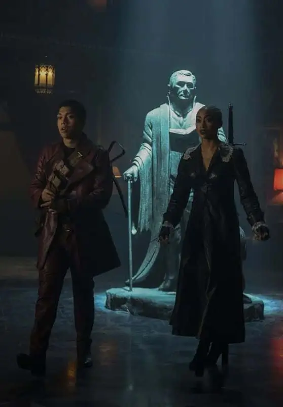 Ambrose Spellman and Prudence from Chilling Adventures of Sabrina, showing the visual contrast between Ambrose's bohemian layered look and Prudence's structured dark aesthetic for a couples Halloween costume pairing