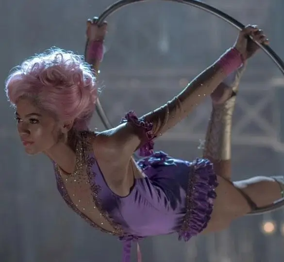 Zendaya as Anne Wheeler in The Greatest Showman wearing her purple and gold trapeze costume with pink wig, used as a Halloween costume styling reference