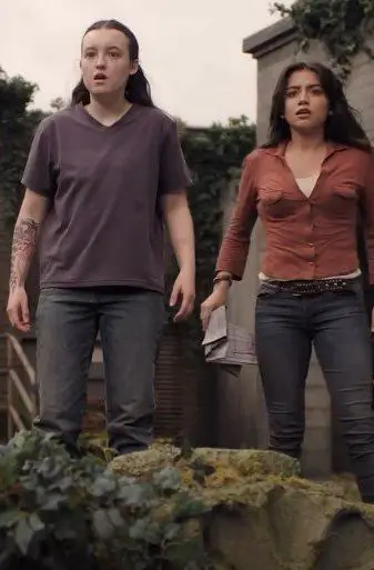 Ellie Williams and Dina from HBO's The Last of Us Season 2 showing Ellie's layered survivor outfit, useful as a group Halloween costume reference