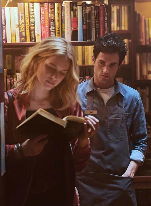 Guinevere Beck and Joe Goldberg from You Netflix together showing the couples Halloween costume pairing, with Beck in her signature relaxed casual outfit and Joe in his characteristic understated bookstore style
