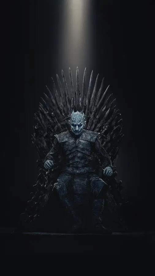 The Night King sitting on the Iron Throne in Game of Thrones, showing his full dark armor costume and blue eyes in a reference shot for Halloween costume planning