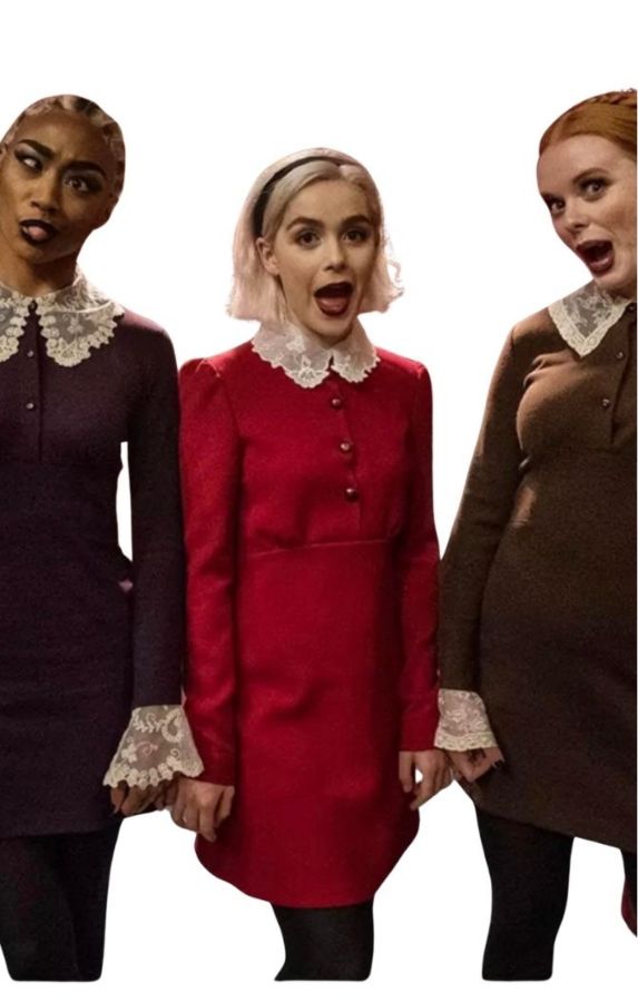 Sabrina Spellman with Prudence Night and Dorcas from Chilling Adventures of Sabrina, showing the visual contrast between Sabrina's red coat and the darker witch aesthetic of the Weird Sisters
