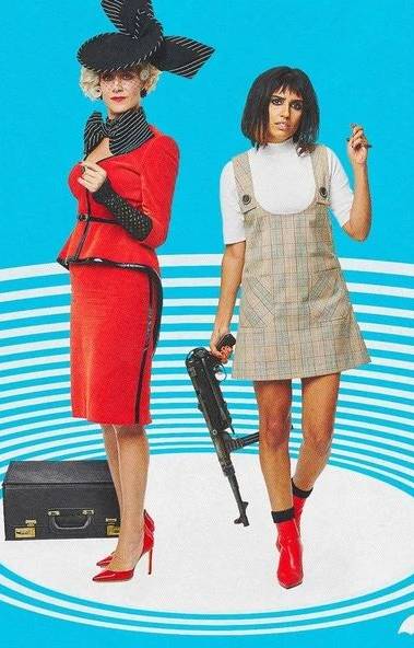 The Handler and Lila Pitts from The Umbrella Academy together, showing the costume contrast between The Handler's leather trench coat and fascinator and Lila's more active combat look, useful for a Halloween duo costume reference
