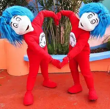 Thing One and Thing Two character costumes at Seuss Landing in Universal Studios Islands of Adventure showing the full red jumpsuit, blue afro hair, and numbered badges that inspire the Halloween costume build