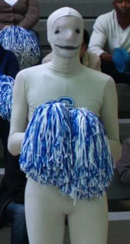 Greendale Human Being mascot appearing on the sidelines in Community, wearing the grey bodysuit with a hand drawn face
