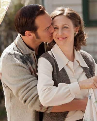 Ed and Lorraine Warren from The Conjuring standing together in their period-accurate outfits
