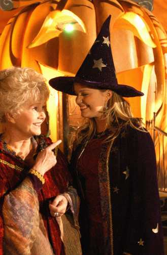 Marnie Piper wearing a purple velvet robe with star and moon patches and a black witch hat in Halloweentown