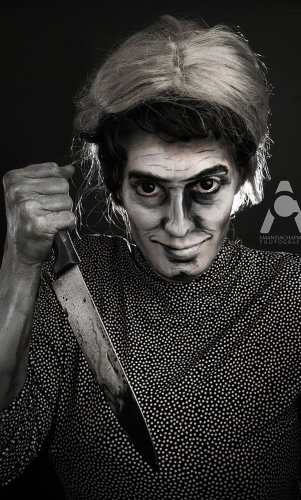 Norman Bates dressed as Mother holding the knife prop from Psycho