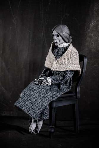 Norman Bates dressed as Mother, seated in the fruit cellar chair in Psycho