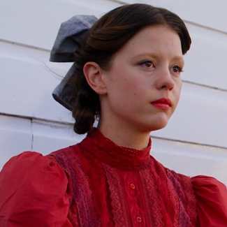 Pearl full costume reference from the 2022 film showing the red dress, wig, and axe prop