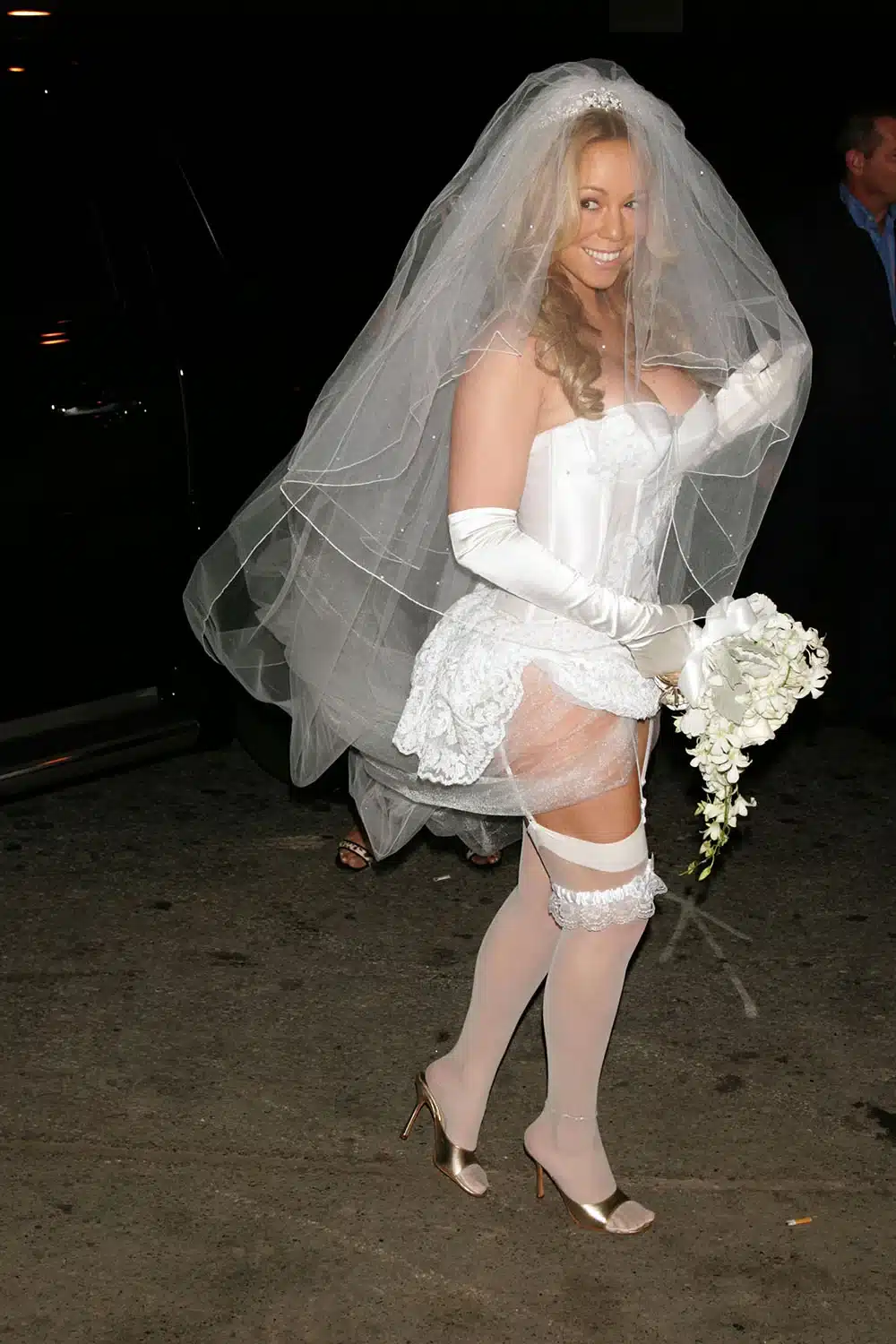 Mariah Carey in a strapless white corset, veil and garter as a bride for Halloween 2004