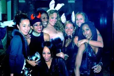 Mariah Carey in white bunny ears posing with a group of friends in costume for Halloween 2002
