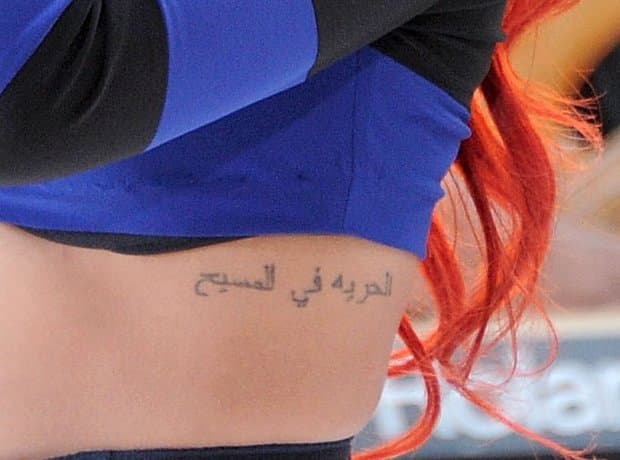 Rihanna's Arabic script tattoo running down the left side of her ribcage