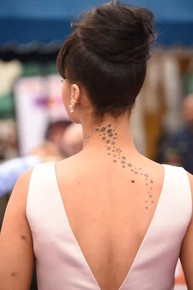 Line of small star tattoos running from the back of Rihanna's neck down her upper back